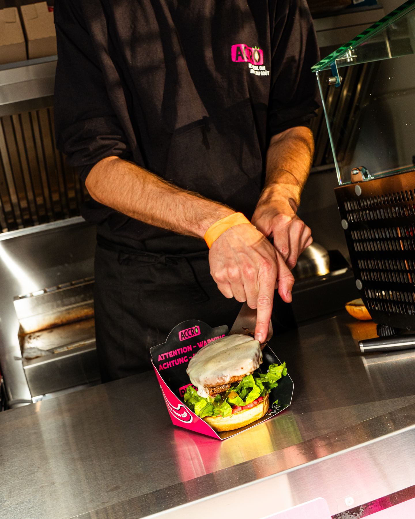 Ein Burger wird in der Küche eines Food Trucks angerichtet