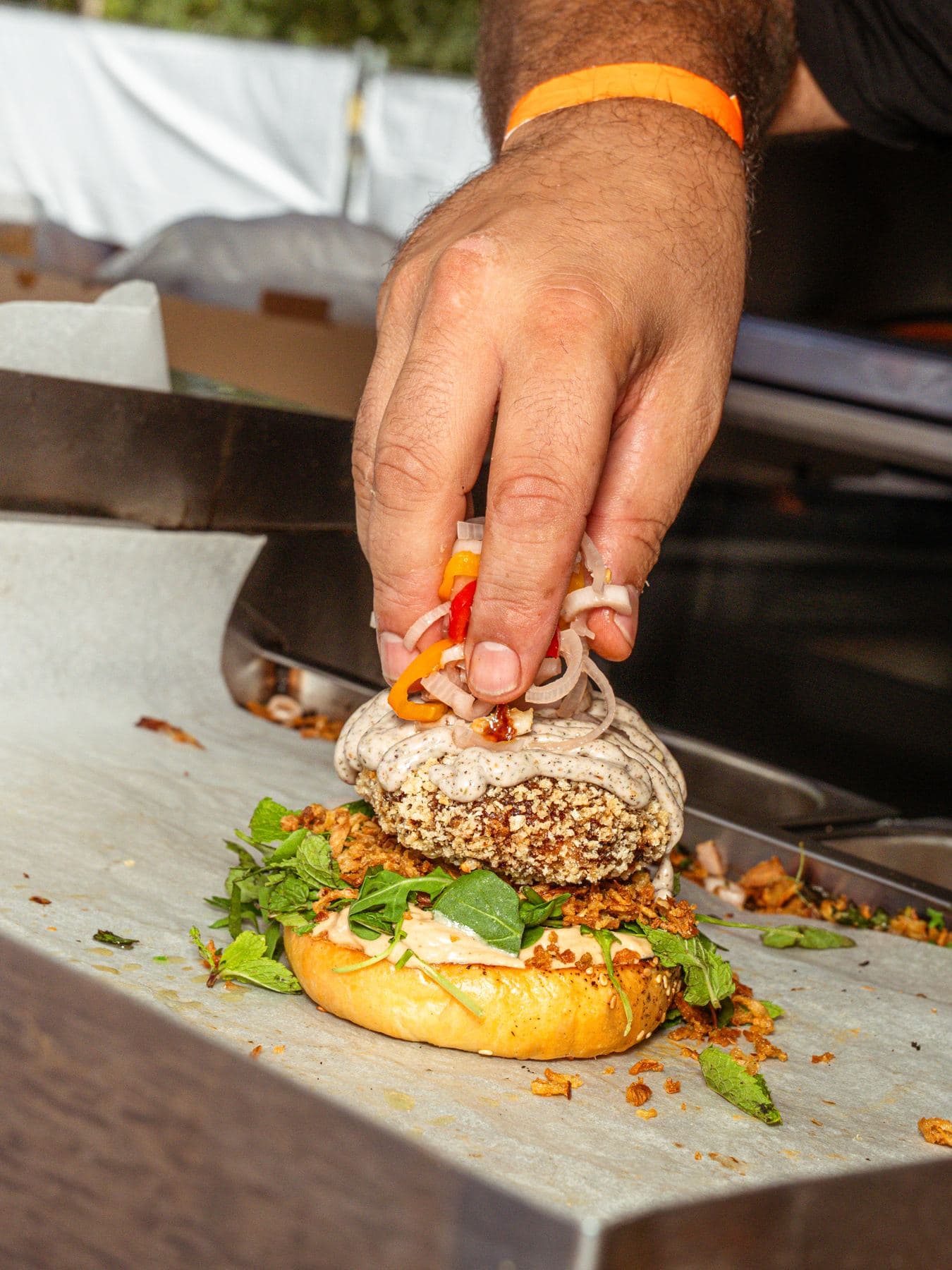 Foodtrucker legt die letzte Zutat auf einen Burger