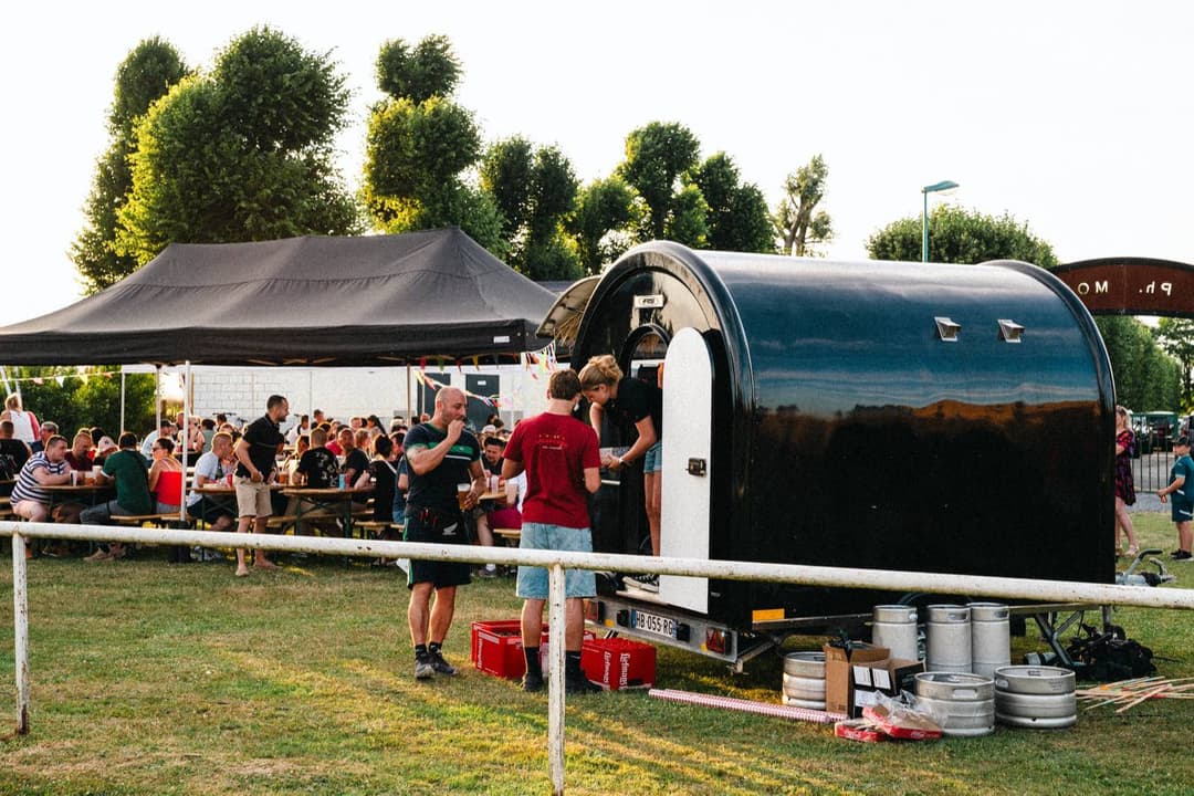 Food Truck auf einer Abendveranstaltung, Gäste vor dem Anhänger