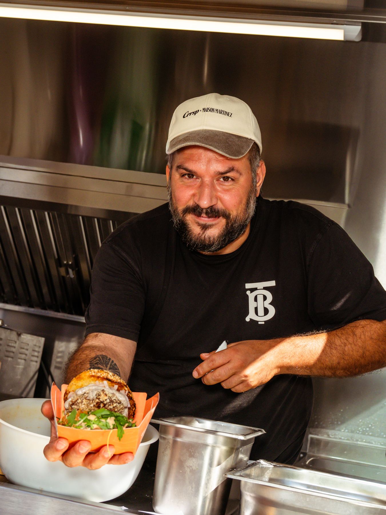 Koch präsentiert in seinem Food-Truck-Anhänger ein Gericht