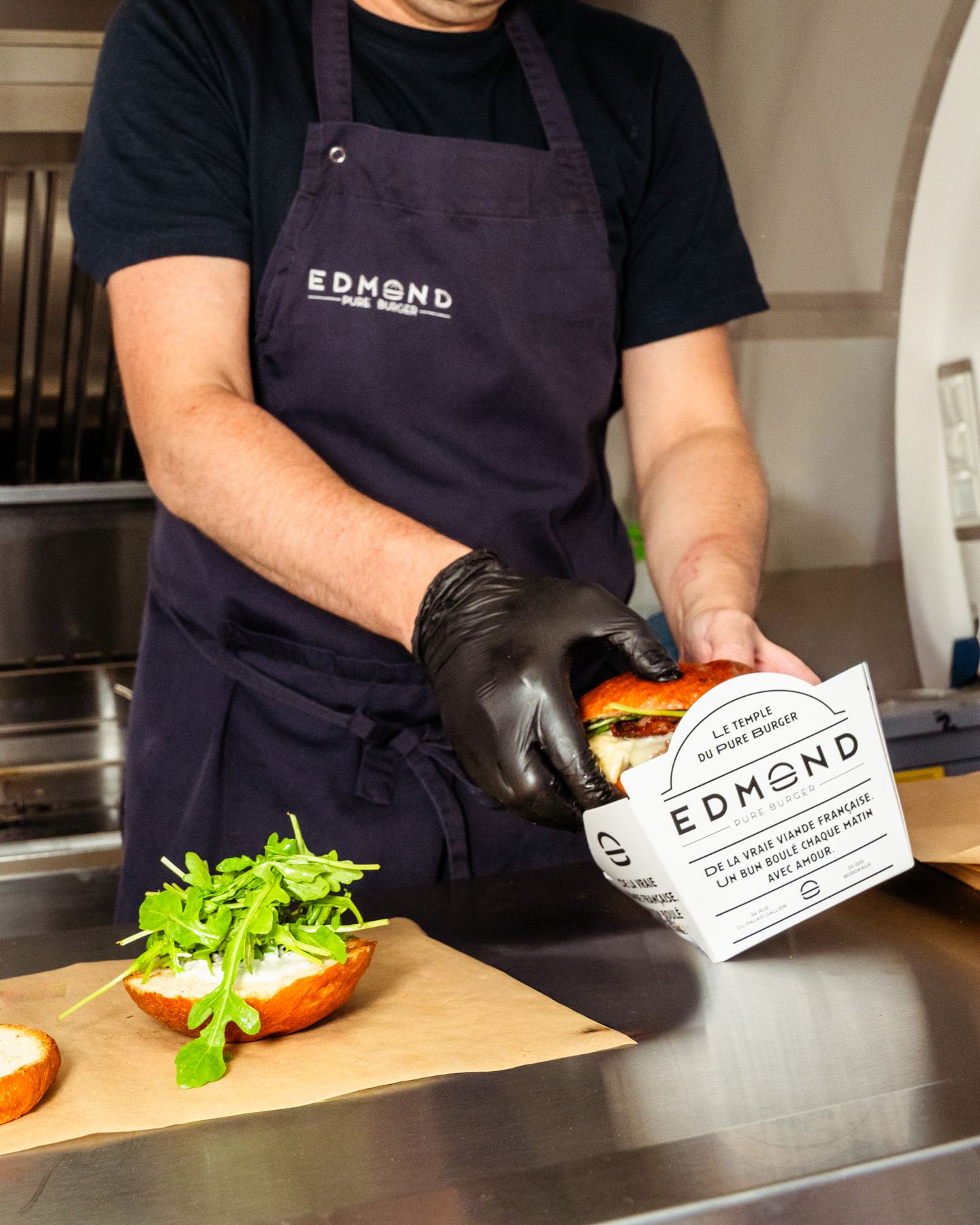 Ein Burger wird in der Küche eines Food Trucks belegt